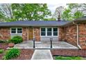 Inviting brick home with a wooden front door, covered porch, and manicured landscaping at 7180 W Sacramento Dr, Greenfield, IN 46140