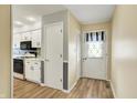 Inviting entryway with wood floors leading to a bright kitchen with white cabinets at 7702 Dornock Dr, Indianapolis, IN 46237