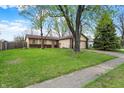 Ranch-style home with well-maintained lawn, mature trees, and attached two-car garage at 7702 Dornock Dr, Indianapolis, IN 46237