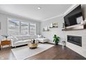 Bright living room features a white sectional sofa, modern fireplace, and large windows with great natural light at 8180 E 116Th St, Fishers, IN 46038