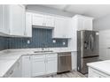 Stylish kitchen boasts white cabinetry, stainless appliances, and a striking backsplash at 838 N Tacoma Ave, Indianapolis, IN 46201