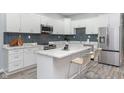 Modern kitchen featuring white cabinets, stainless appliances, and a center island with seating at 838 N Tacoma Ave, Indianapolis, IN 46201