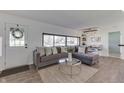 Open concept living room with gray sectional sofa, large windows, and adjacent dining area at 91 Crestview Dr, Greenwood, IN 46143