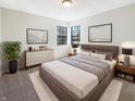 Cozy bedroom with a large bed, white walls, and dark framed windows with natural light at 9162 Hadway Dr, Indianapolis, IN 46256