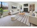 Bright living room featuring a fireplace, plush seating, and large windows with a view to the backyard at 9162 Hadway Dr, Indianapolis, IN 46256