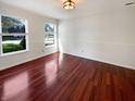 This empty room with three windows and hardwood flooring, perfect for your interior design ideas at 10376 Alice Ct, Fishers, IN 46038