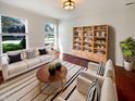 Bright living room with hardwood floors, a white sofa, decorative shelving, and plenty of natural light at 10376 Alice Ct, Fishers, IN 46038