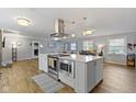 Modern kitchen with stainless steel appliances, custom range hood and a large island at 10421 Hillsdale Dr, Carmel, IN 46032