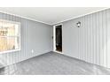 Enclosed sunroom featuring neutral gray walls and ceiling with carpet and access to the exterior at 106 S Wayburn St, Indianapolis, IN 46229