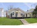 Inviting home with a black porch, light gray siding and lush green front lawn at 109 S 10Th S Ave, Beech Grove, IN 46107