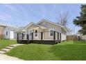 Gray home featuring a cozy porch, clean lines, and a well-maintained lawn at 109 S 10Th S Ave, Beech Grove, IN 46107