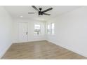 Bright living room featuring light colored floors, white walls, and a modern ceiling fan at 109 S 10Th S Ave, Beech Grove, IN 46107