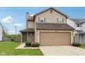 Charming two-story home features a two-car garage, green shutters, tidy landscaping and a well-maintained lawn at 10905 Amber Glow Ln, Indianapolis, IN 46229