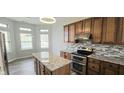 Stylish kitchen featuring granite countertops, stainless steel appliances, tiled backsplash, and hardwood floors at 13648 Seven Oaks Dr, Fishers, IN 46038