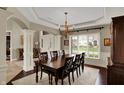 Formal dining room with a large table, chandelier, and view of the landscaped front yard at 13682 Frenchmans Creek, Carmel, IN 46032