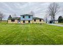 Spacious home featuring a large green lawn, mature trees, and a light blue storage shed at 1387 W Furry Rd, Fountaintown, IN 46130