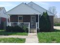 Inviting brick home with a charming covered front porch, complete with white railings and flower boxes at 1640 Lawton Ave, Columbus, IN 47201