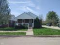 Quaint brick home featuring a cozy covered front porch and a neatly kept lawn at 1640 Lawton Ave, Columbus, IN 47201