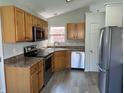 Cozy kitchen with stainless steel appliances, wood cabinets, and a view of the backyard at 1959 Crystal Bay East Dr, Plainfield, IN 46168