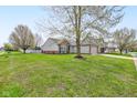 Spacious yard view of the exterior with a two car garage, vinyl siding, and well maintained lawn at 2075 Sea Hero Ct, Indianapolis, IN 46234