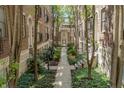 Exterior view of a charming courtyard nestled between brick apartment buildings with lush landscaping at 226 N Cleveland St # 226C, Indianapolis, IN 46204