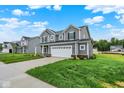 Attractive home with gray siding, a two-car garage, and a green lawn, perfect for suburban living at 2712 Glade Ave, Plainfield, IN 46168