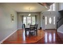 Spacious dining room with hardwood floors, a large window, and a staircase in the background at 3389 Grant Ct, Columbus, IN 47203