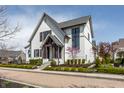 Charming two-story home with white brick, black trim, and lush landscaping at 496 Bridgemont Ln, Carmel, IN 46032