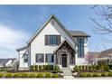 Charming two-story home with white brick, black trim, and covered front porch at 496 Bridgemont Ln, Carmel, IN 46032