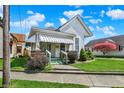 Inviting two-story home featuring a covered front porch and beautifully landscaped front yard at 508 Miller Ave, Shelbyville, IN 46176
