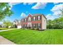 Beautiful two-story home featuring a well-manicured lawn and mature trees at 5595 Auburndale Dr, Bargersville, IN 46106
