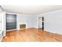 Living room with hardwood floors, fireplace, built-in shelving, and access to other rooms at 6017 E 52Nd Pl, Indianapolis, IN 46226