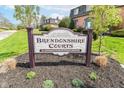 Community sign for Brendonshire Courts Condominiums is surrounded by a green grassy area and dark mulch at 6017 E 52Nd Pl, Indianapolis, IN 46226