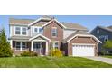 Charming two-story home with a brick and gray siding exterior, attached garage, and a lush front lawn at 6408 Askin Dr, Indianapolis, IN 46259