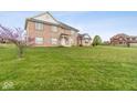 Charming brick home with large front yard and mature landscaping at 6519 Rothchild Blvd, Indianapolis, IN 46278