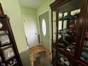 Hallway with green walls and trim, wood flooring, and a lighted display case at 712 E Mckenzie Rd, Greenfield, IN 46140