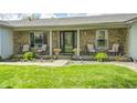 A cozy front porch with chairs, planters, and stone accents offers a warm welcome to this charming home at 7170 Janean Dr, Brownsburg, IN 46112