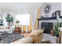 Elegant living room featuring brick fireplace, hardwood floors, and bright windows at 7594 W Williamswood Dr, New Palestine, IN 46163