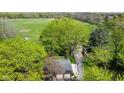 Aerial view of property featuring a home, detached garage, tractor, driveway and large open fields at 7825 N County Road 650 E, Brownsburg, IN 46112