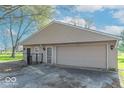 Detached garage featuring neutral siding, lighting fixtures, and a gated entry at 7825 N County Road 650 E, Brownsburg, IN 46112