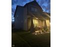 Side view of a two-story home featuring a covered porch with seating and a well-maintained yard at dusk at 912 Grassy Branch Dr, Indianapolis, IN 46239