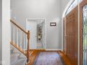 Bright foyer features hardwood floors, staircase, coat closet, and a warm and welcoming atmosphere at 933 Hummingbird Ln, Columbus, IN 47203