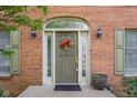 Charming front entrance featuring an arched doorway, a cheerful floral wreath, and stylish sconce lighting at 933 Hummingbird Ln, Columbus, IN 47203