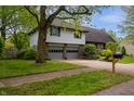 Charming two-story home with a well-maintained lawn, attached two-car garage, and mature landscaping at 961 Parkside Dr, Columbus, IN 47203