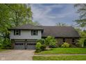 Charming two-story home with a well-maintained lawn, attached two-car garage, and mature landscaping at 961 Parkside Dr, Columbus, IN 47203