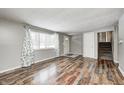 Spacious living room featuring hardwood floors, a window, and a white door leading to the outside at 9829 Chambray Dr, Indianapolis, IN 46280