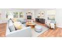 Bright living room with large windows, a cozy fireplace, and stylish, modern furniture at 10362 Delphi Ct, Fishers, IN 46038