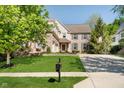 A well-manicured lawn leads up to a brick and siding home with a three-car garage at 10752 Tallow Wood Ln, Indianapolis, IN 46236