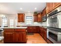 Traditional kitchen features stainless steel appliances, granite countertops, and cherry cabinets at 10752 Tallow Wood Ln, Indianapolis, IN 46236
