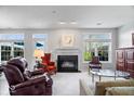 Bright living room with a fireplace, large windows, neutral decor, and ample seating at 11264 Fonthill Dr, Indianapolis, IN 46236